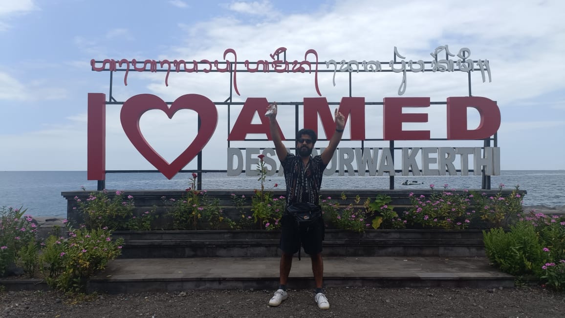 Amed beach Bali0 Adit sarin posing in fornt of Amed beach Hoarding