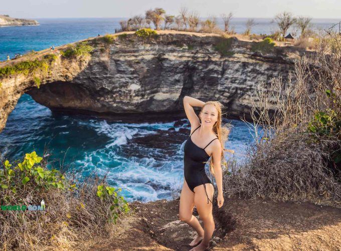 European girl posing in front of Broken Beach Nusa Penida on Bali tour package for Europeans