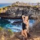 European girl posing in front of Broken Beach Nusa Penida on Bali tour package for Europeans