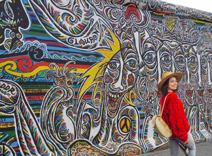 Tourist posing in front of Berlin Wall during 10 nights 11 days Germany tour package.