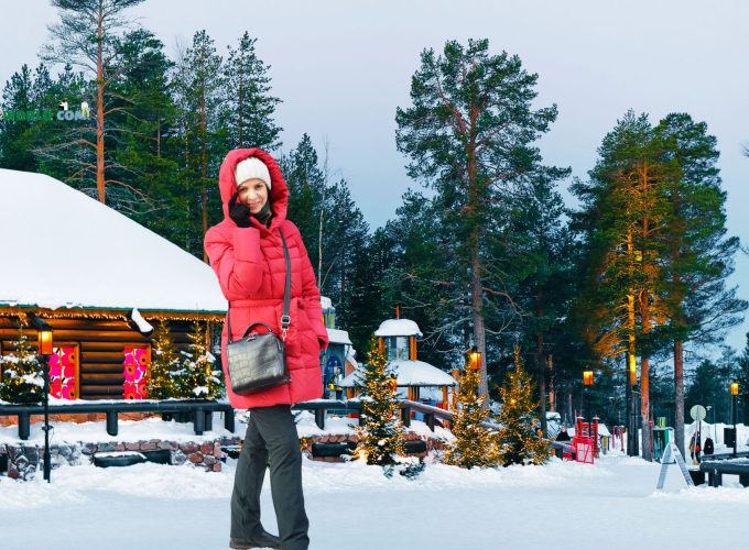 Solo girl traveler posing in front of Santa Claus Village, Rovaniemi during 7 nights 8 days Solo Finland tour package