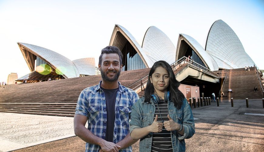 Anjali and Srinivas smiling while posing in front of the iconic Sydney Opera House during their Australian tour from India.
