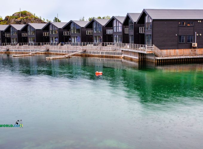 Cottages around a serene lake at Senja Hamn i, featuring picturesque views and tranquil surroundings.