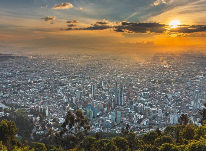 Aerial view of Bogotá city, Colombia, showcasing the urban landscape with mountains in the background.