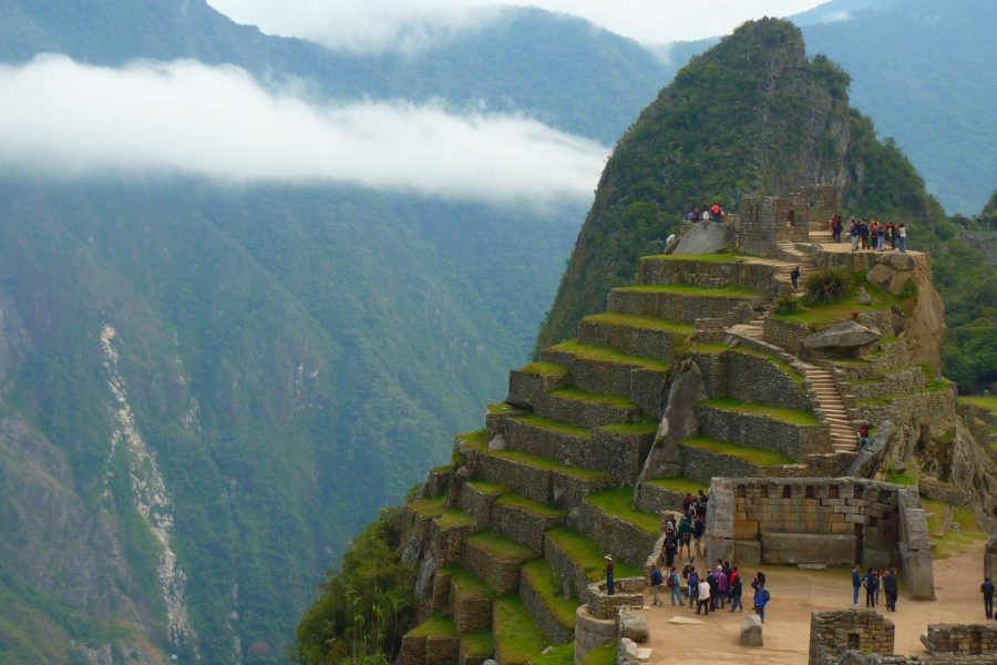 Aerial view of Machu Picchu, showcasing its ancient ruins surrounded by lush green mountains.