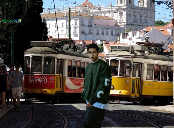 A tourist posing in front of tram 28 in Portugal's Lisbon.