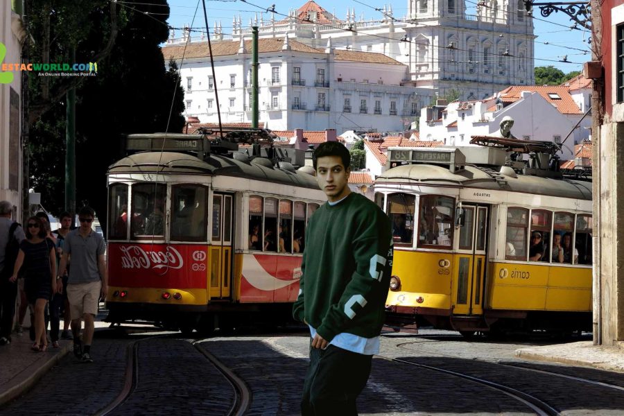 A tourist posing in front of tram 28 in Portugal's Lisbon.