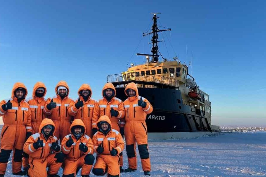 Travelers from India enjoying the 12-Day Finland Northern Lights tour in front of the Icebreaker cruise in Kemi